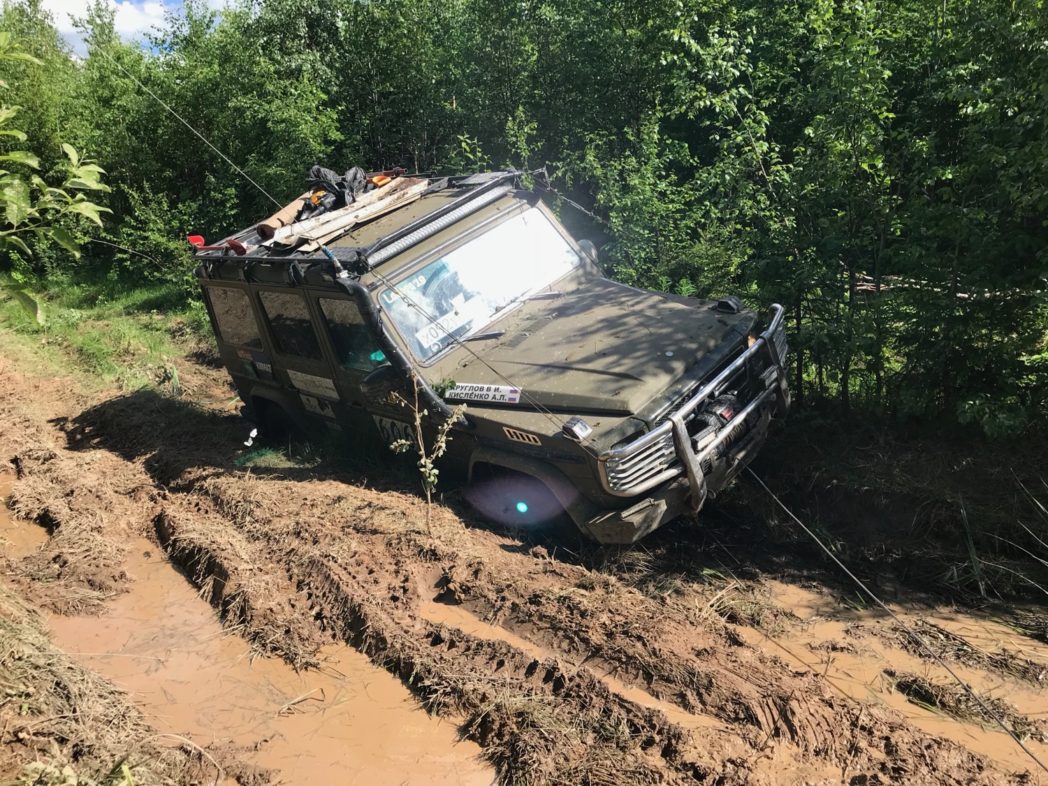 Внедорожник преодолевает грязь на лесной дороге